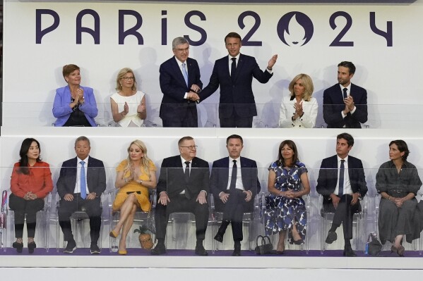 French President Emmanuel Macron, top, third right, and IOC President Thomas Bach greet during the 2024 Summer Olympics closing ceremony at the Stade de France, Sunday, Aug. 11, 2024, in Saint-Denis, France. (AP Photo/Rebecca Blackwell)
