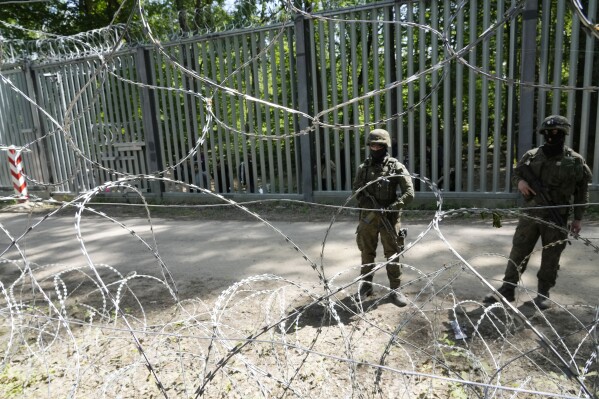 Polish troops guard the metal barrier border with Belarus, in Bialowieza Forest, on Wednesday, May 29, 2024. Poland says neighboring Belarus and its main supporter Russia are behind a surging push by migrants in Belarus toward the European Union. (AP Photo/Czarek Sokolowski)