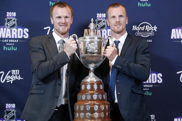 FILE - Daniel Sedin, right, and Henrik Sedin pose with the King Clancy Memorial Trophy after winning the award at the NHL Awards, Wednesday, June 20, 2018, in Las Vegas. Swedes Henrik and Daniel Sedin and Daniel Alfredsson have been elected to the Hockey Hall of Fame. Goaltender Roberto Luongo, Finnish women’s star Riikka Sallinen and builder Herb Carnegie were also selected Monday, June 27, 2022, to be inducted in November. (AP Photo/John Locher, File)