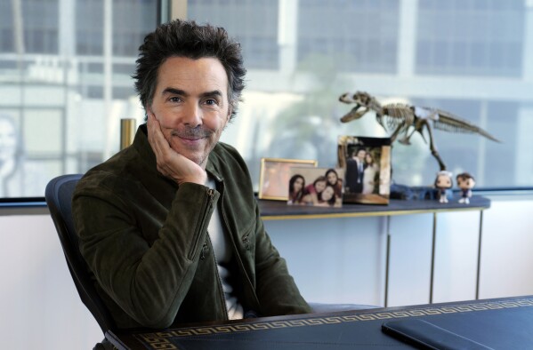 Producer-director Shawn Levy poses for a portrait in his office, Thursday, Oct. 12, 2023, in West Hollywood, Calif., to promote his limited-series "All the Light We Cannot See" based on the best-selling novel. The dinosaur model behind Levy is a reference to the 2006 film "Night at the Museum," which he directed. (AP Photo/Chris Pizzello)