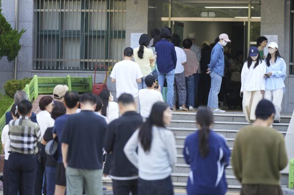 People wait in line to cast their votes for the presidential election at a polling station in Seoul, South Korea, Tuesday, June 3, 2025. (AP Photo/Lee Jin-man)