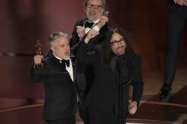 Dave Mullins, from left, Brad Booker, and Sean Ono Lennon accept the award for best animated short for "War Is Over! Inspired by the Music of John &amp; Yoko" during the Oscars on Sunday, March 10, 2024, at the Dolby Theatre in Los Angeles. (AP Photo/Chris Pizzello)