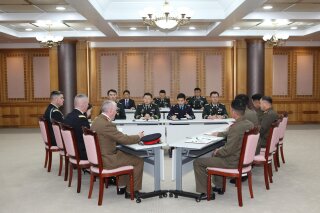 
              In this photo provided by South Korea Defense Ministry, the U.S.-led United Nations Command, left, South Korean, center, and North Korean, right, military officers attend a meeting at the southern side of Panmunjom in the Demilitarized Zone, South Korea, Monday, Oct. 22, 2018. Military officers from the two Koreas and the U.S.-led U.N. Command met again at the Koreas' border village Monday to examine an ongoing effort to disarm the area. (South Korea Defense Ministry via AP)
            