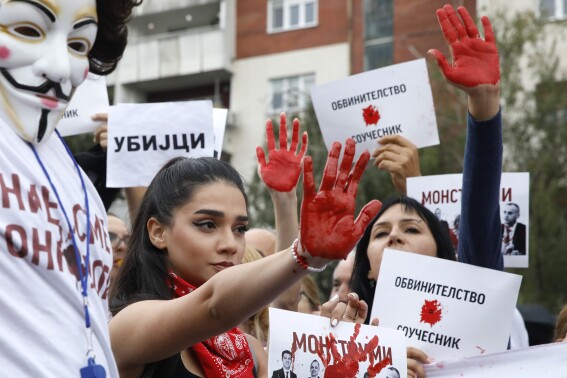 Protestors with red painted hands chant "Murderers" in front of the Government building in Skopje, North Macedonia, on Monday, Sept. 4. 2023. Thousands have gathered late on Monday in front of the government in North Macedonia's capital Skopje to protest on scandal that broke after media reported that employees in the state running Clinic of Oncology allegedly were selling on a black market a million of dollars' worth clinic supply of drugs needed for cancer treatment. (AP Photo/Boris Grdanoski)