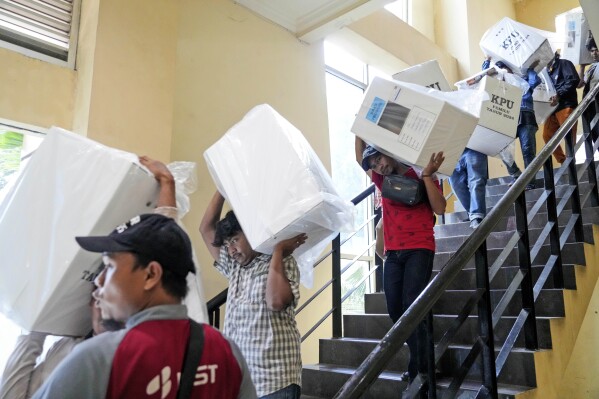 Workers carry ballot boxes to be distributed to polling stations ahead of the Feb. 14 election, in Jakarta, Indonesia, Tuesday, Feb. 13, 2024. Indonesia, the world's third-largest democracy, will open its polls on Wednesday to nearly 205 million eligible voters in presidential and legislative elections, the fifth since Southeast Asia's largest economy began democratic reforms in 1998. (AP Photo/Tatan Syuflana)