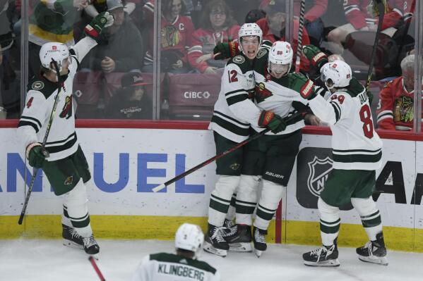 Minnesota Wild's Marcus Johansson (90) celebrates with teammates Frederick Gaudreau (89) and Matt Boldy (12) after scoring a goal during the third period of an NHL hockey game against the Chicago Blackhawks Monday, April 10, 2023, in Chicago. Minnesota won 4-2. (AP Photo/Paul Beaty)