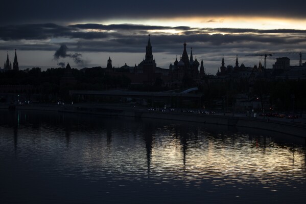 FILE - The Kremlin, left, and St. Basil Cathedral, center right, are reflected in the Moskva River during sunset in Moscow, Russia, Wednesday, May 20, 2020. Russia's 2024 presidential elections aren't expected to bring change to the Kremlin. (AP Photo/Pavel Golovkin, File)
