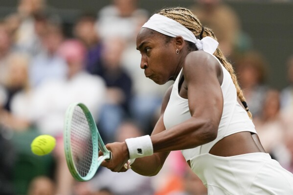 Coco Gauff of the United States plays a backhand return to Anca Todoni of Romania during their match on day three at the Wimbledon tennis championships in London, Wednesday, July 3, 2024. (AP Photo/Mosa'ab Elshamy)