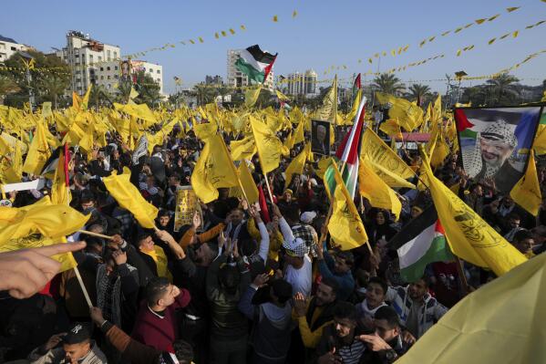 Palestinian Fatah supporters chant slogans and wave the movement's flags during a rally marking the 58th anniversary of Fatah movement foundation at the Unknown soldier square in Gaza City, Saturday, Dec. 31, 2022. Hundreds of thousands of Palestinians thronged a Gaza City park Saturday to mark the 58th founding anniversary of Fatah party, a rare show of popularity in the heartland of the militant Hamas group, Fatah's main rival. (AP Photo/Adel Hana)