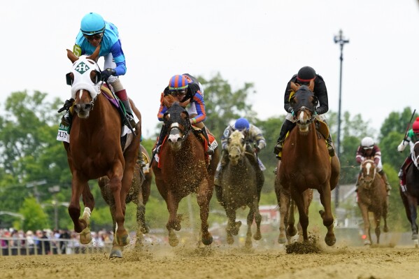 John Velazquez, left, atop Gun Song, wins the Black-Eyed Susan horse race at Pimlico Race Course, Friday, May 17, 2024, in Baltimore. (AP Photo/Julio Cortez)