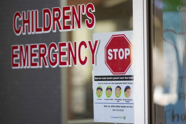 A sign is posted in German at the entrance of the children's emergency room at Covenant Children's Hospital, Tuesday, Feb. 25, 2025, in Lubbock, Texas. (AP Photo/Julio Cortez)