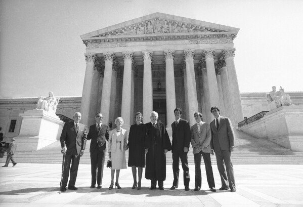 FILE - Justice Sandra Day O'Connor poses for photos on the steps of the Supreme Court before being sworn in with her family on Sept. 26, 1981. From left are: Justice O'Connor's father, Harry Day; her husband, John J. O'Connor; her mother, Ada Mae Day; O'Connor; Chief Justice Warren Burger; and her sons, Brian, Jay and Scott. O'Connor, who joined the Supreme Court in 1981 as the nation's first female justice, has died at age 93. (AP Photo/Bob Daugherty, File)