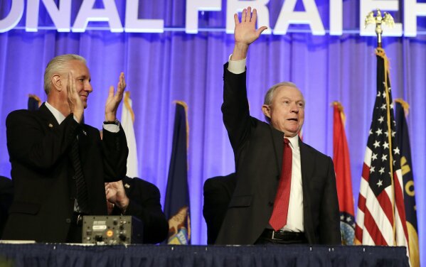 
              Attorney General Jeff Sessions, right, is applauded at the Fraternal Order of Police convention Monday, Aug. 28, 2017, in Nashville, Tenn. Sessions said President Donald Trump will revive a program that provides local police departments with surplus military equipment such as high-caliber weapons and grenade launchers. (AP Photo/Mark Humphrey)
            