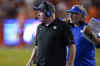 Kentucky head coach Mark Stoops, left, paces the sideline during the second half of an NCAA college football game against Florida, Saturday, Sept. 10, 2022, in Gainesville, Fla. (AP Photo/John Raoux)