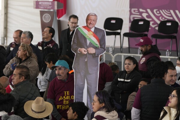 Supporters of Mexican President Andrés Manuel López Obrador hold a life-size image of him during a ceremony to inaugurate a 