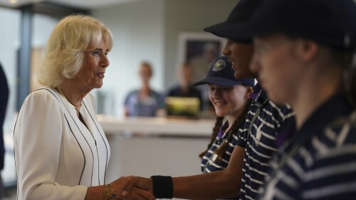 Koningin Camilla, links, ontmoet meisjes en jongens Larissa, Sean Michael en Cassie tijdens hun bezoek op dag 10 van de Wimbledon-kampioenschappen 2023 op de All England Lawn Tennis and Croquet Court in Londen, woensdag 12 juli 2023. Foto door Jones/Pool via AP)
