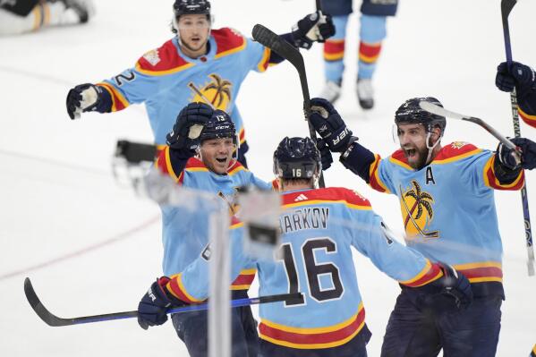 Florida Panthers center Aleksander Barkov (16) is mobbed by teammates after he scored to tie the game near the end of the third period of an NHL hockey game against the Boston Bruins, Saturday, Jan. 28, 2023, in Sunrise, Fla. The Panthers beat the Bruins 4-3 in overtime. (AP Photo/Wilfredo Lee)