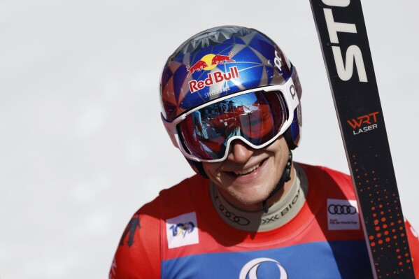 Switzerland's Marco Odermatt celebrates at the finish area of an alpine ski, men's World Cup super-G race, in Saalbach, Austria, Friday, March 22, 2024. (AP Photo/Alessandro Trovati)