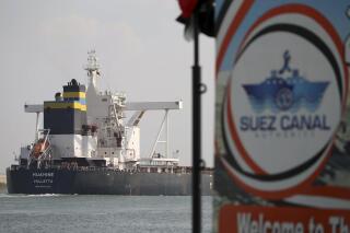 FILE - A cargo ship sails through the town of Ismailia, Egypt, March 30, 2021. Egypt’s Suez Canal said Sunday, Jan. 2, 2022, that its annual revenues reached $6.3 billion last year, the highest in the crucial waterway's history. (AP Photo/AP Photo/Ayman Aref, File)