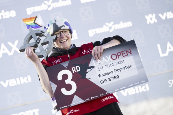 FILE - Jay Riccomini of the United States celebrates on the podium after the final run of the freeski slopestyle competition at Laax Open in Laax, Switzerland, Sunday, Jan. 21 2024. On July 20, 2021, Riccomini, then still a teenager, announced on social media that he was a gay transgender man who would from then on use the pronouns he and him. “I want the world to know who I am and who I’m meant to be so I can pursue it openly,” he wrote. (Mayk Wendt/Keystone via AP, File)