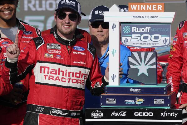 Chase Briscoe, front, celebrates with his trophy after winning a NASCAR Cup Series auto race at Phoenix Raceway, Sunday, March 13, 2022, in Avondale, Ariz. (AP Photo/Darryl Webb)