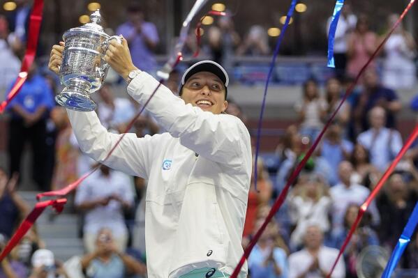 Iga Swiatek, of Poland, holds up the championship trophy after defeating Ons Jabeur, of Tunisia, to win the women's singles final of the U.S. Open tennis championships, Saturday, Sept. 10, 2022, in New York. (AP Photo/Frank Franklin II)