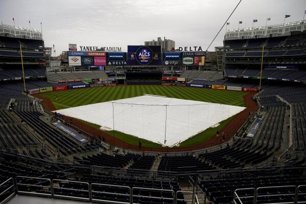 The rain tarp covers the field as a light rain falls on Yankee Stadium before Game 4 of an American League Championship baseball series between the New York Yankees and the Houston Astros, Sunday, Oct. 23, 2022, in New York. (AP Photo/Julia Nikhinson)