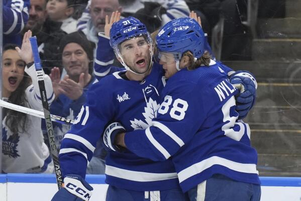Toronto Maple Leafs right wing William Nylander (88) celebrates after his goal against the New York Islanders with teammate John Tavares (91) during second-period NHL hockey game action in Toronto, Ontario, Monday, Jan. 23, 2023. (Nathan Denette/The Canadian Press via AP)