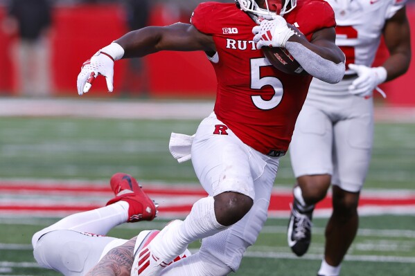 Rutgers running back Kyle Monangai (5) runs for yardage Ohio State defensive end Jack Sawyer (33) during the second half of a NCAA college football game, Saturday, Nov. 4, 2023, in Piscataway, N.J. Ohio State won 35-16. (AP Photo/Noah K. Murray)