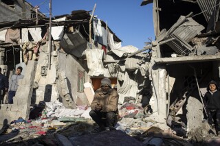 Palestinians look at the destruction after an Israeli strike in Rafah, southern Gaza Strip, Thursday, Jan. 18, 2024. (AP Photo/Fatima Shbair)