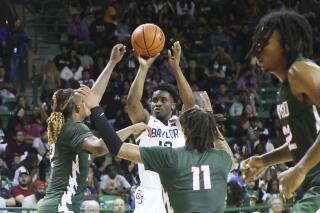 Baylor guard Adam Flagler scores over Mississippi Valley State guards Arecko Gipson, left, and Terry Collins (11) in the second half of an NCAA college basketball game, Monday, Nov. 7, 2022, in Waco, Texas. Baylor won 117-53. (AP Photo/Rod Aydelotte)