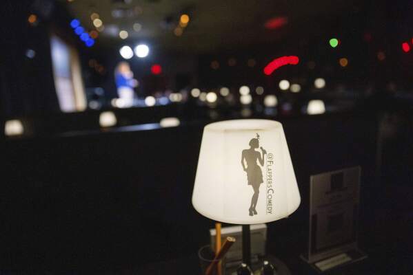 A light with the name Flappers Comedy is visible as Ashley Brooke Roberts performs during Stand Up For Climate on Thursday, March 20, 2025, in Burbank, Calif. (AP Photo/Ethan Swope)