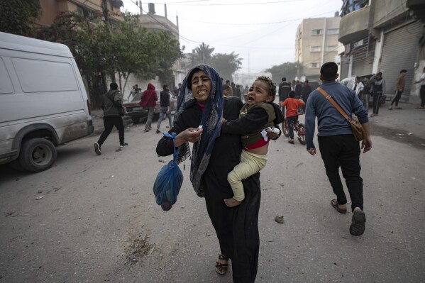Palestinians evacuate from a site hit by an Israeli bombardment on Rafah, southern Gaza Strip, Wednesday, Dec. 20, 2023. (AP Photo/Fatima Shbair)