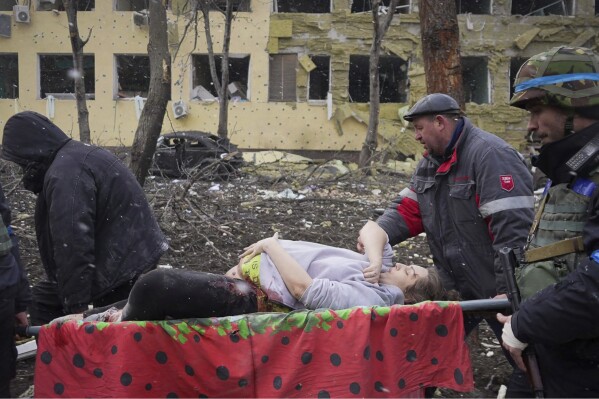 FILE - Ukrainian emergency workers and volunteers carry an injured pregnant woman from a maternity hospital damaged by an airstrike in Mariupol, Ukraine, on March 9, 2022. The image appears in a scene from the documentary "20 Days in Mariupol." (AP Photo/Evgeniy Maloletka, File)