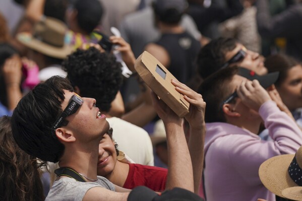 People use special glasses to watch a total solar eclipse in Mazatlan, Mexico, Monday, April 8, 2024. (AP Photo/Fernando Llano)