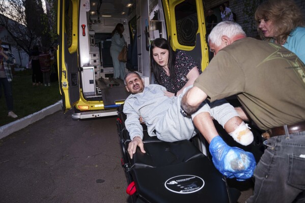 An injured Ukrainian soldier who was a prisoner of war is placed on a stretcher after being returned to his home country by Russia, April. 19, 2025. (AP Photo/Evgeniy Maloletka)