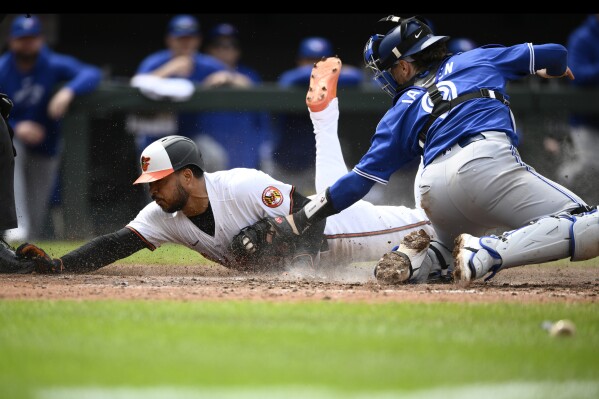 Baltimore Orioles' Anthony Santander, left, is tagged out at home by Toronto Blue Jays catcher Danny Jansen, right, during the eighth inning of a baseball game, Wednesday, May 15, 2024, in Baltimore. The Orioles won 3-2. (Ǻ Photo/Nick Wass)
