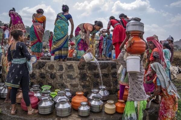 Women gather around a well to draw water in the village of Telamwadi, northeast of Mumbai, India, Saturday, May 6, 2023. Tankers bring water from the Bhatsa River after it has been treated with chlorine. There have been protests in the region since so much of the river water is diverted to urban areas, including Mumbai. (AP Photo/Dar Yasin)