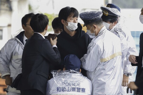 FILE - A man who was later identified as Ryuji Kimura is arrested after what appeared to be a pipe bomb was thrown at Japanese Prime Minister Fumio Kishida during his visit at a port in Wakayama, western Japan, on April 15, 2023. Prosecutors in Japan indicted the 24-year-old man Wednesday, Sept. 6, 2023 on attempted murder and other charges in the explosive attack on Prime Minister Fumio Kishida in April, Japanese media reported. (Kyodo News via AP, File)