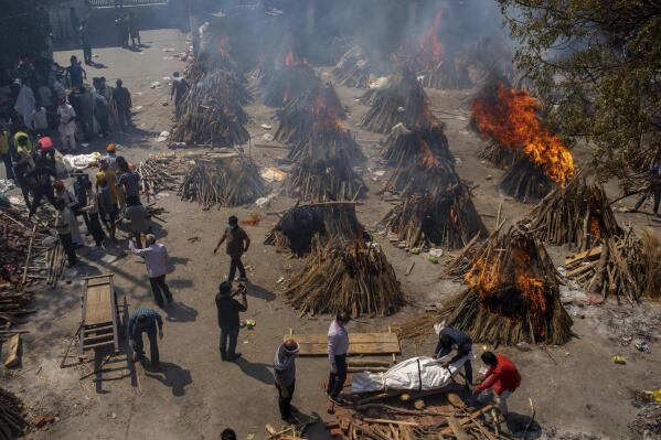 Multiple funeral pyres of victims of COVID-19 burn in an area that has been converted for mass cremation in New Delhi, India, Saturday, April 24, 2021. Authorities are scrambling to get medical oxygen to hospitals where COVID-19 patients are suffocating from low supplies. The effort Saturday comes as the country with the world's worst coronavirus surge set a new global daily record of infections for the third straight day. The 346,786 infections over the past day brought India's total past 16 million. (AP Photo/Altaf Qadri)