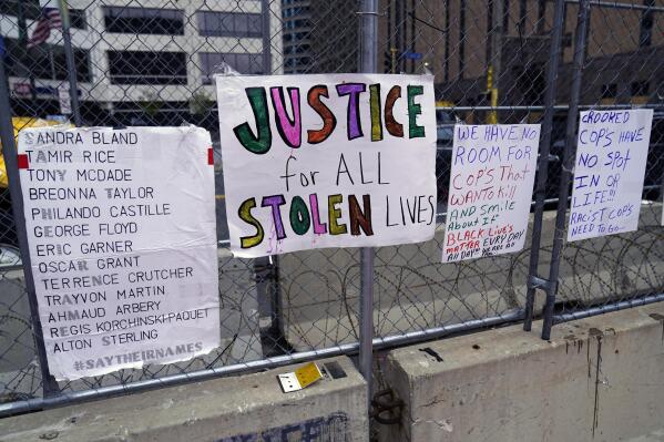 New signs are on a fence at the Hennepin County Government Center, Monday, April 19, 2021, in Minneapolis where closing arguments are being heard in the trial of former Minneapolis police officer Derek Chauvin continues. Chauvin is charged with murder in the death of George Floyd during an arrest last may in Minneapolis. (AP Photo/Jim Mone)