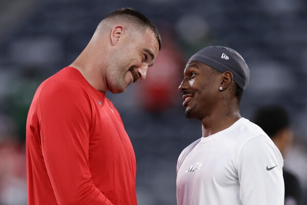 Kansas City Chiefs tight end Travis Kelce, left, talks with New York Jets wide receiver Mecole Hardman Jr. before playing in an NFL football game, Sunday, Oct. 1, 2023, in East Rutherford, N.J. (AP Photo/Adam Hunger)
