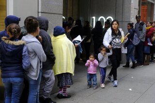 File - In this Jan. 31, 2019, file photo, hundreds of people overflow onto the sidewalk in a line snaking around the block outside a U.S. immigration office with numerous courtrooms in San Francisco. Santa Clara and San Francisco have filed suit against the Trump administration over its new controversial "public charge" rule that restricts legal immigration. This lawsuit is the first after the Department of Homeland Security's announcement Monday, Aug. 12, 2019, that it would deny green cards to migrants who use Medicaid, food stamps, housing vouchers or other forms of public assistance. (AP Photo/Eric Risberg, File)