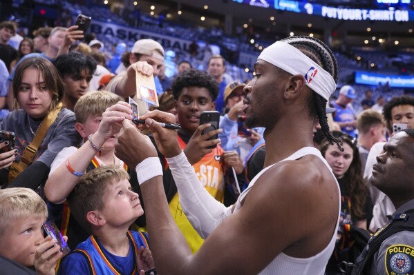 Oklahoma City Thunder guard Shai Gilgeous-Alexander signs autographs prior to Game 1 vs. Minnesota Timberwolves in a NBA basketball Western Conference Finals playoff series Tuesday, May 20, 2025, in Oklahoma City. (AP Photo/Nate Billings)