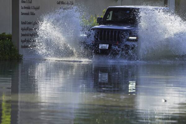 Um SUV passa pelas enchentes que cobrem uma estrada em Dubai, Emirados Árabes Unidos, quarta-feira, 17 de abril de 2024.  Fortes tempestades atingiram os Emirados Árabes Unidos na terça-feira, a cidade desértica de Dubai com as chuvas mais fortes em mais de um ano e meio.  Em poucas horas, inundou as principais rodovias e partes do aeroporto internacional.  (Foto AP/John Gambrell)