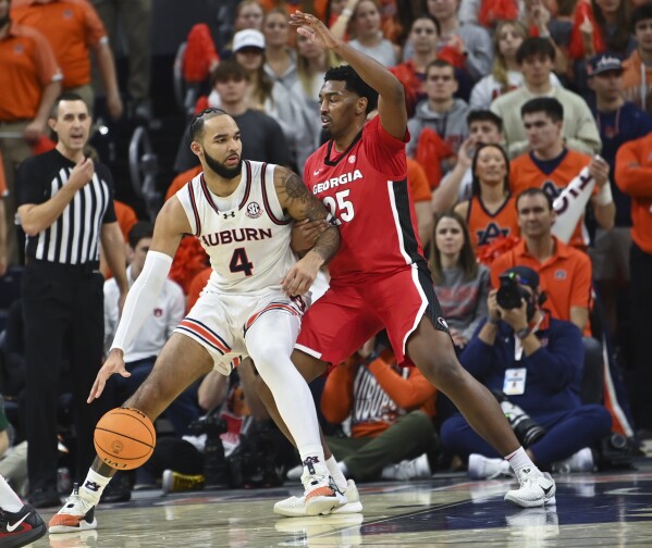 Auburn forward/center Johni Broome (4) tries works the ball inside as Georgia forward Justin Abson (25) defends during the first half an NCAA college basketball game Saturday, Feb. 22, 2025, in Auburn, Ala. (AP Photo/Julie Bennett)