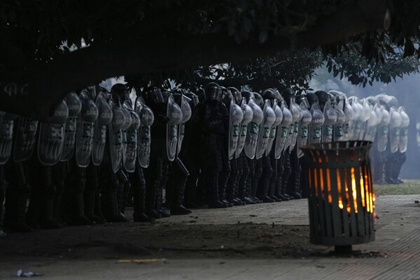 Police line up during clashes with anti-government protesters outside Congress where lawmakers debate a reform bill promoted by Javier Milei in Buenos Aires, Argentina, Wednesday, June 12, 2024. (AP Photo/Natacha Pisarenko)