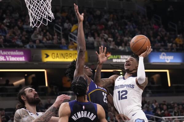 Memphis Grizzlies guard Ja Morant (12) shoots around Indiana Pacers forward Jalen Smith (25) during the first half of an NBA basketball game in Indianapolis, Saturday, Jan. 14, 2023. (AP Photo/AJ Mast)