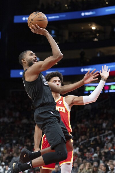 Brooklyn Nets forward Mikal Bridges scores against Atlanta Hawks forward Jalen Johnson during the first half of an NBA basketball game Wednesday, Nov. 22, 2023, in Atlanta. (AP Photo/Hakim Wright Sr.)