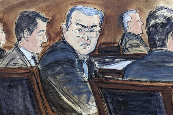 In this courtroom sketch in Federal court, in New York, Tuesday, Feb. 20, 2024, former Honduran President Juan Orlando Hernandez, seated center at the defense table, turns to looks at prospective jurors, during the jury selection process at the start of his trial. Nearly two years after his arrest and extradition to the U.S., Hernandez went on trial Tuesday in Manhattan federal court on drug trafficking and weapons charges. (Elizabeth Williams via AP)